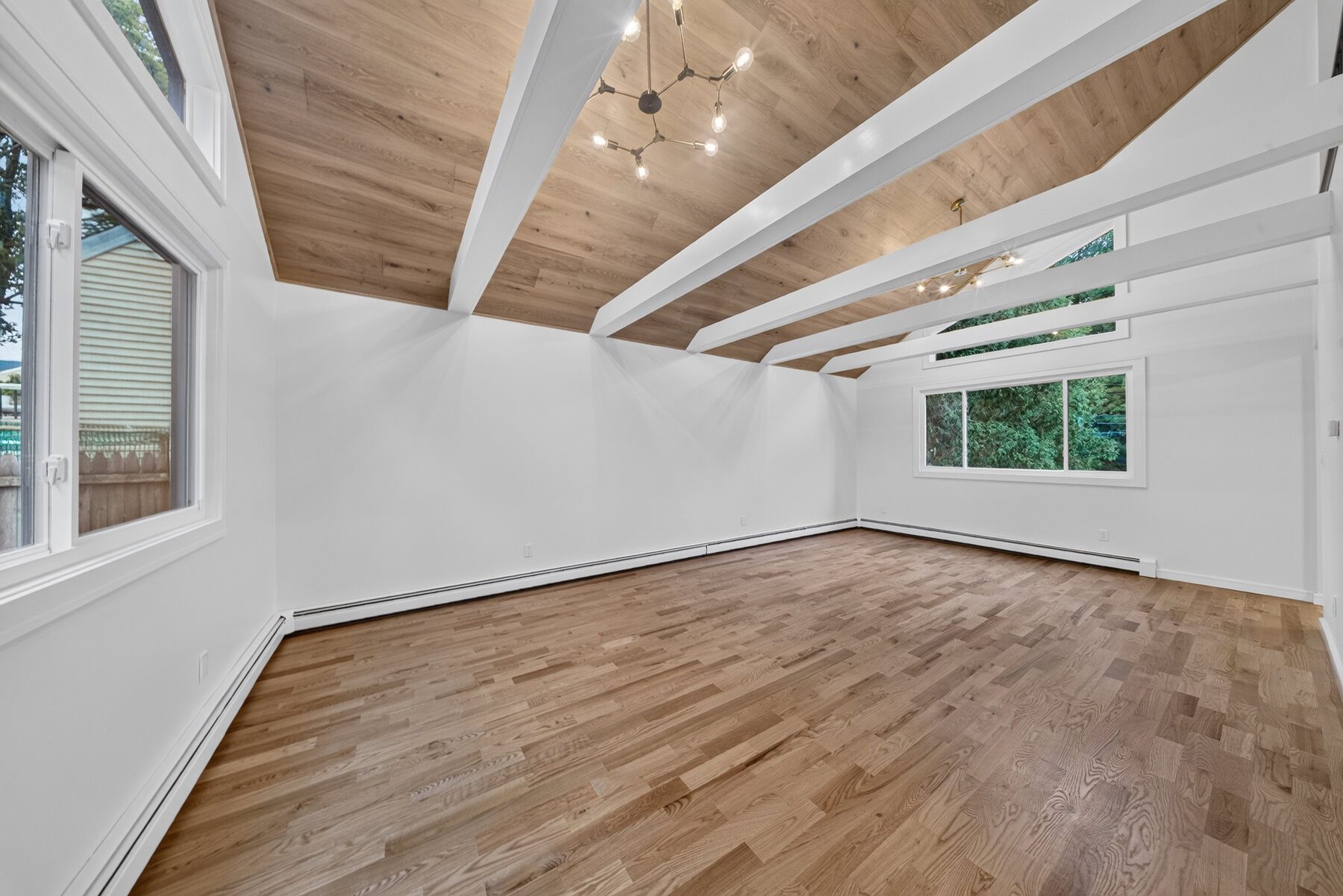 Vaulted great room with white beams and warm wood ceiling